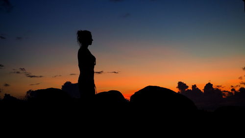 Silhouette man standing on cliff against sky during sunset