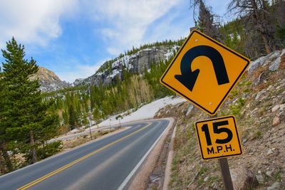 Information sign by road against sky