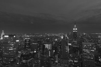 Illuminated cityscape against sky at night