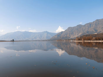 Scenic view of lake and mountains against blue sky