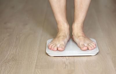 Low section of person standing on hardwood floor