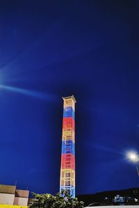 Low angle view of illuminated building against blue sky