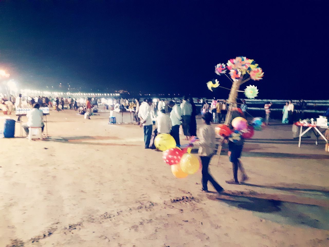 GROUP OF PEOPLE AT BEACH AGAINST SKY