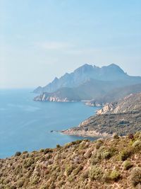 Scenic view of sea and mountains against sky