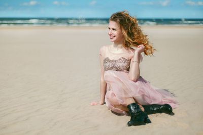 Portrait of smiling woman sitting on beach