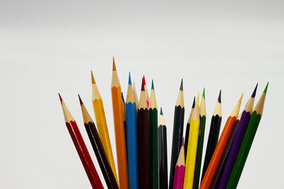 High angle view of colored pencils against white background