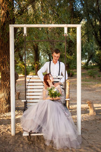 Wedding couple in the woods on a white swing. young people in love love with each other.