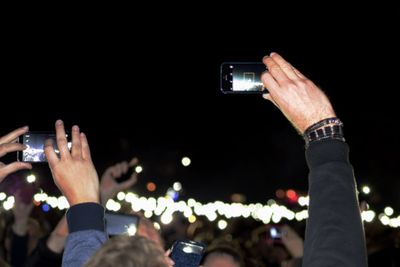 Rear view of woman photographing through smart phone