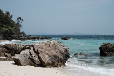 Scenic view of rocks on beach against sky