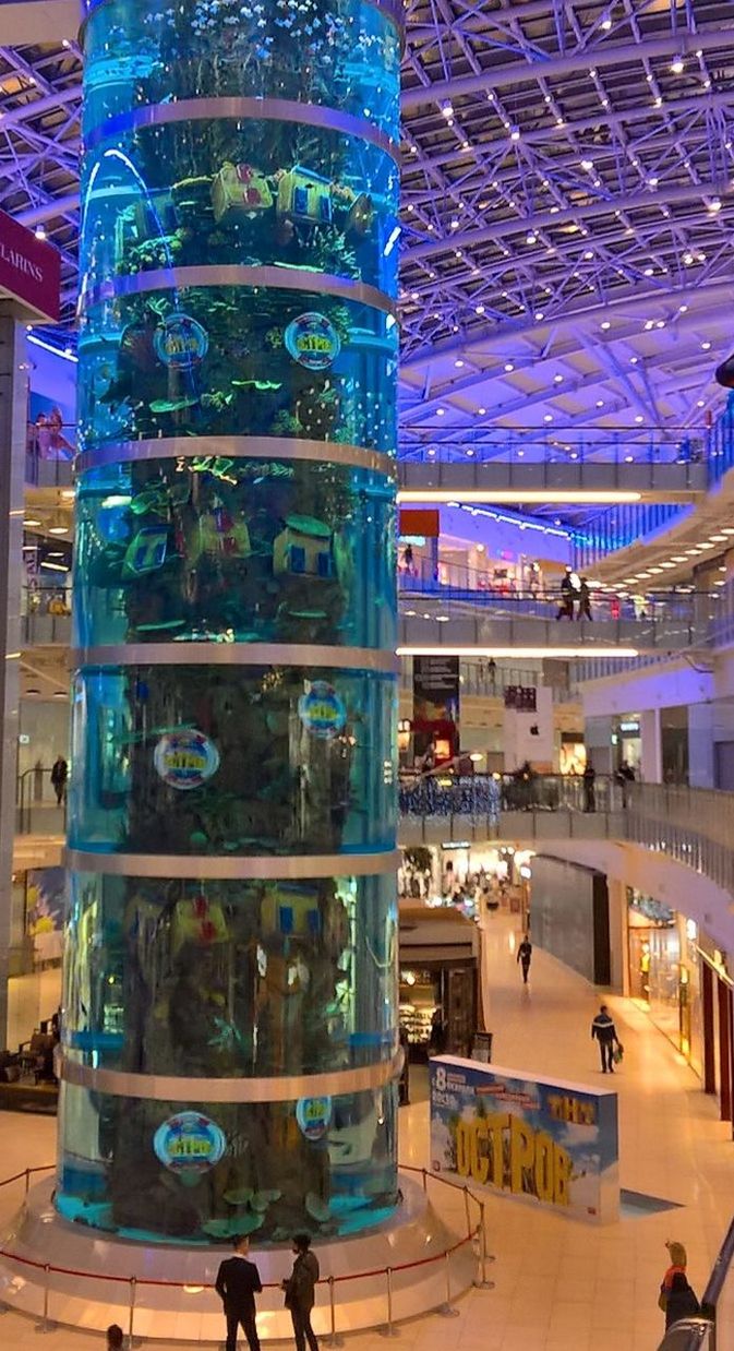 indoors, glass - material, table, drink, restaurant, transparent, architecture, food and drink, built structure, incidental people, arrangement, drinking glass, glass, chair, reflection, refreshment, blue, window, modern