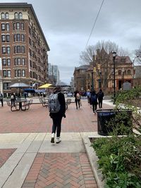 People walking on street amidst buildings in city