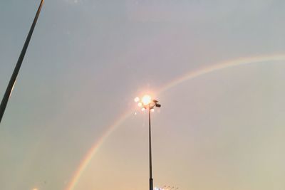 Low angle view of illuminated street light against rainbow