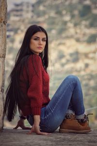 Portrait of young woman sitting outdoors