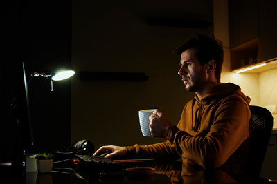 Tired man works late at workplace, use computer