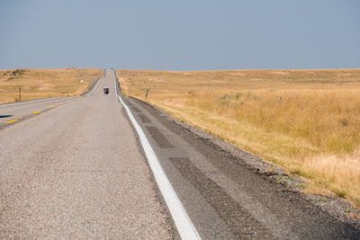 Road amidst field against sky