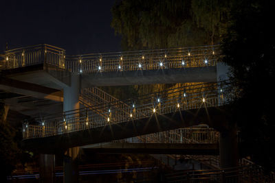 Low angle view of illuminated footbridge at night