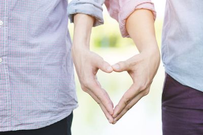 Midsection of couple holding hands