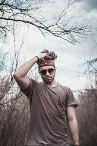 Young man standing against sky