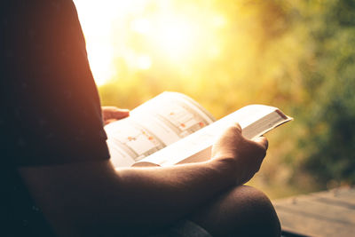 Midsection of person holding book