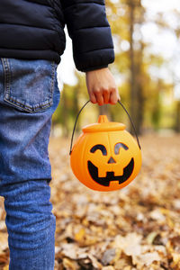 Midsection of man holding pumpkin