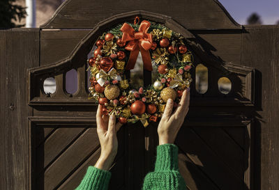 Female hanging up a fir wreath for advent. christmas eve and decorating. new year