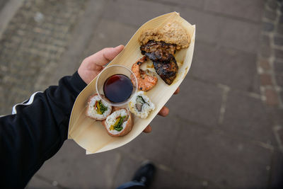 Close-up of cropped hand holding sushi