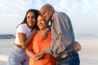 Senior couple with their granddaughter walking at the beach together