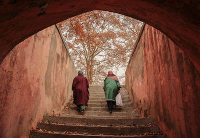 Rear view of people moving up on steps