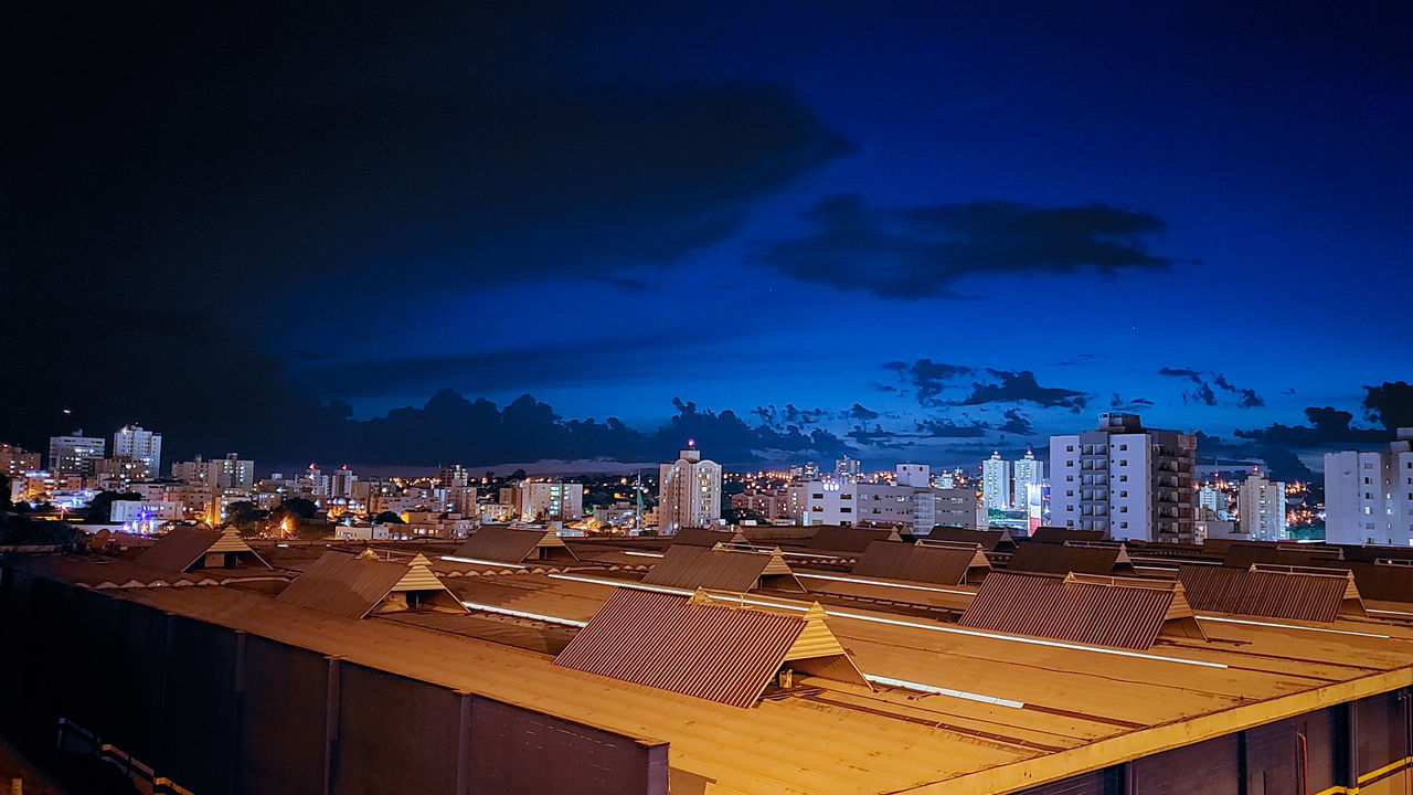 HIGH ANGLE VIEW OF ILLUMINATED CITY BUILDINGS AT NIGHT