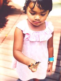 High angle view of cute girl holding butterfly