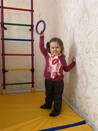 Portrait of girl standing against wall