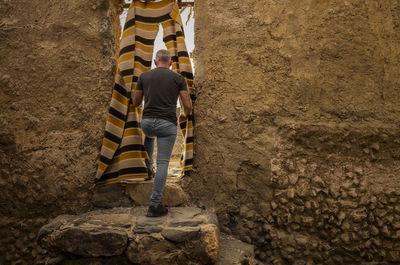 Low section of man standing on rock