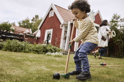 Toddler boy playing croquet