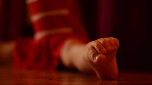 Low section of girl with legs apart sitting on floor