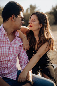 Couple cuddling while sitting outdoors