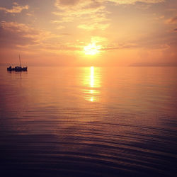 Scenic view of boat in sea against sky during sunset