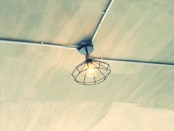 Low angle view of light bulb hanging from ceiling