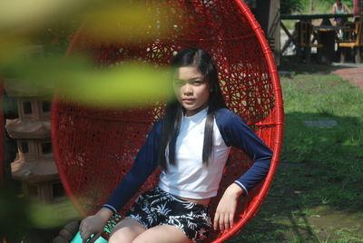 Portrait of young woman sitting on swing