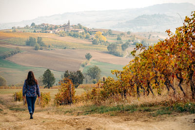 Rear view of woman walking on field