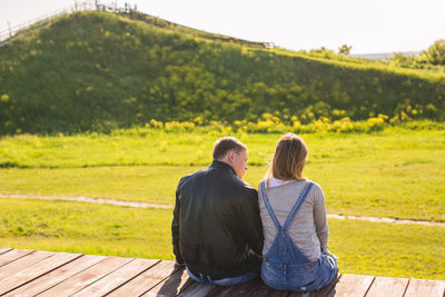 Rear view of couple sitting outdoors