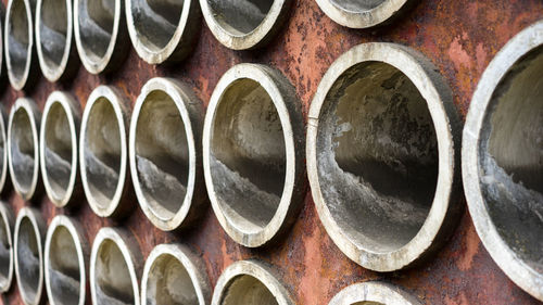 Full frame shot of cement pipes in metallic wall