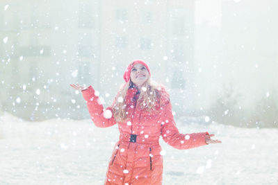 Woman with arms raised standing in snow