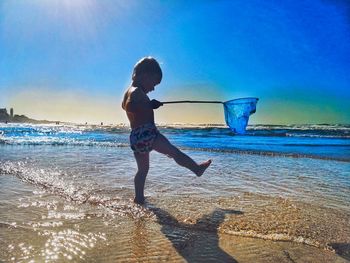 Full length of boy on beach against sky