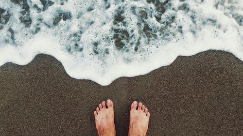 Low section of person standing on beach