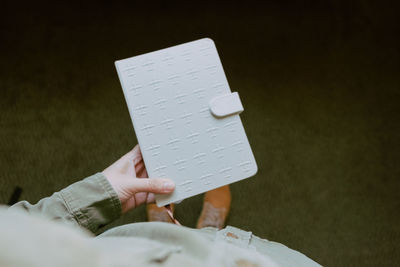 High angle view of person holding diary