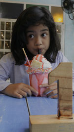 Little  girl eating ice cream at an indoor cafe in indoors cafe