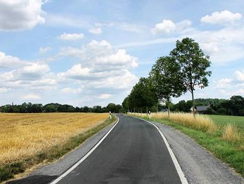 Empty road passing through field