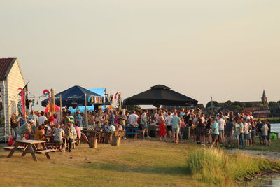 Group of people on field against clear sky