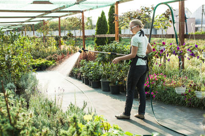 Full length of woman standing in greenhouse