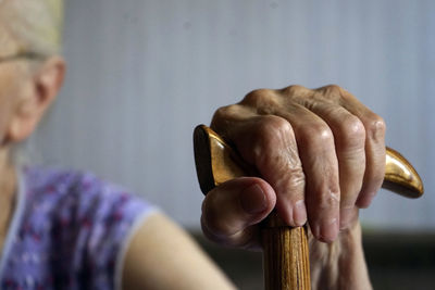 Close-up of senior woman holding walking cane